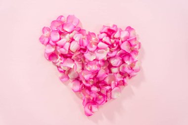 Düz yatıyordu. Pembe arka planda pembe gül yapraklarından yapılmış kalp şekli.