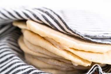 Mutfak havlusuna sarılı taze pişmiş ekmek yığını..