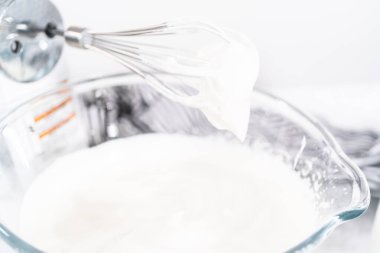 Çikolatalı dondurma yapmak için bardaktaki malzemeleri karıştırıyorum..