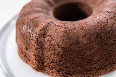 Beyaz pasta standında taze pişmiş çikolatalı kek..