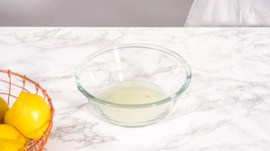 Adım adım. Küçük bir bardağa taze limon suyu sıkıyorum..