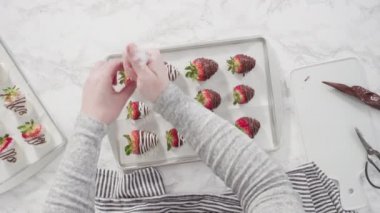 Çikolataya batırılmış organik çilekler parşömen kağıdına kurulanıyor..