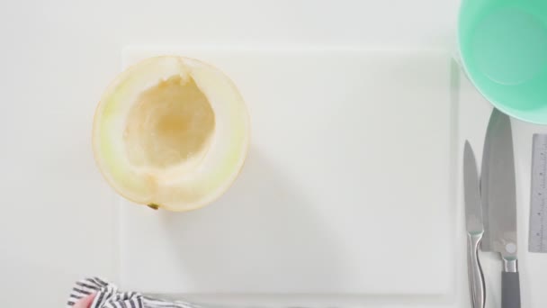 Acostado Slicong Melón Dewlicious Oro Una Tabla Cortar Blanca — Vídeo de stock