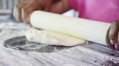 Küçük kız küçük pizzalar için halasının yardımıyla pizza hamuru hazırlıyor..