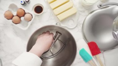 Adım adım. Düz yatıyordu. Üç katlı vanilyalı kek pişirmek için mutfak mikserinin malzemelerini karıştırıyorum..