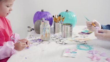 Süslü deniz kızı Cadılar Bayramı balkabağı yaratmak için akrilik boyalı balkabağı boyamak.