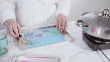 Vanilyalı kekleri süslemek için silikon kalıplı çikolata denizkızı kuyruğu yapıyorum..