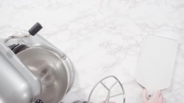 Kırmızı kadife kek pişirmek için ıslak malzemeleri karıştırıyorum..