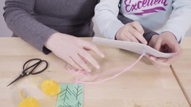 Küçük kız dikiş setiyle dikiş dikmeyi öğreniyor..