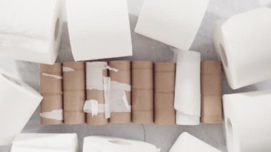 Gri arkaplanda boş tuvalet kağıdı ruloları kullanılıyor.