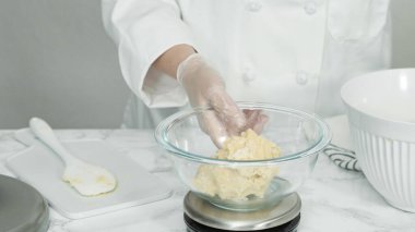 Adım adım. Kırmızı, beyaz ve mavi fırıldak şekerli kurabiyeler pişirmek için dijital mutfak terazisiyle ölçülmüş kurabiye..