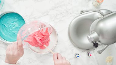 Adım adım. Düz yatıyordu. Üç katlı vanilyalı kek pişirmek için yemek boyasını kek hamuruna karıştırıyorum..