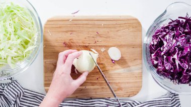 Düz yatıyordu. Adım adım. Tahta kesme tahtasına organik sarı soğan koymak..