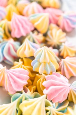 Beyaz servis tabağında çok renkli tek boynuzlu at kurabiyeleri..