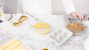 Adım adım. Çikolata parçacıklı kurabiye yapmak için cam kasede malzemeleri karıştırıyorum..