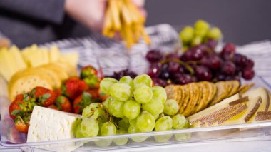 Adım adım. Taze meyve, gurme peynir ve kraker ile peynir tabağı hazırlıyorum..