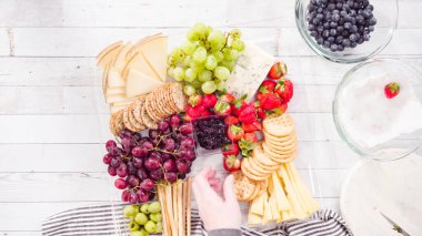 Düz yatıyordu. Adım adım. Taze meyve, gurme peynir ve kraker ile peynir tabağı hazırlıyorum..