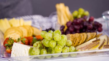 Adım adım. Taze meyve, gurme peynir ve kraker ile peynir tabağı hazırlıyorum..