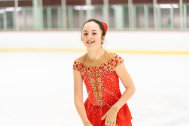 Genç kız buz pateni pistinde artistik patinaj yapıyor..