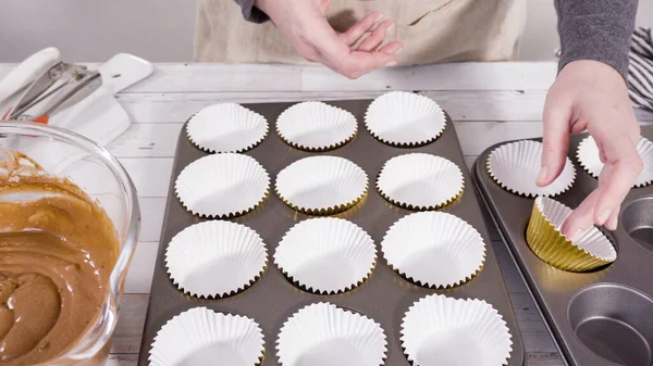 Cupcake pan lined with foil cupcake cups to bake chocolate raspberry cupcakes.