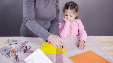 İnşaat kağıdından el yapımı Babalar Günü kartı yapan küçük bir kız..