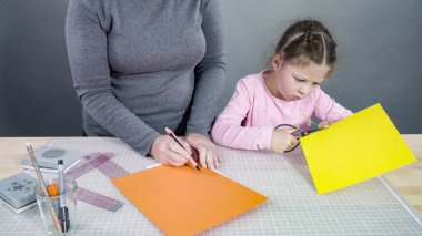 İnşaat kağıdından el yapımı Babalar Günü kartı yapan küçük bir kız..