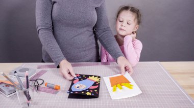 İnşaat kağıdından el yapımı Babalar Günü kartı yapan küçük bir kız..