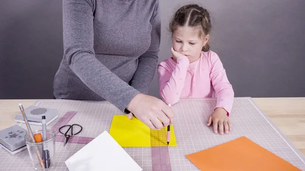 İnşaat kağıdından el yapımı Babalar Günü kartı yapan küçük bir kız..