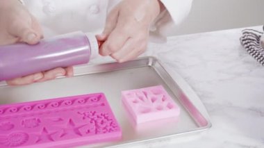 Vanilyalı kekleri süslemek için silikon kalıplı çikolata denizkızı kuyruğu yapıyorum..