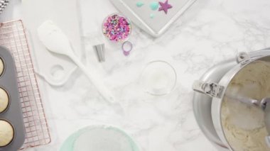 Düz yatıyordu. Adım adım. Denizkızı temalı vanilyalı kekler için tereyağlı krema yapmak için mutfak mikserinde malzemeler karıştırılıyor..