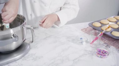 Adım adım. Denizkızı temalı vanilyalı kekler için tereyağlı krema yapmak için mutfak mikserinde malzemeler karıştırılıyor..