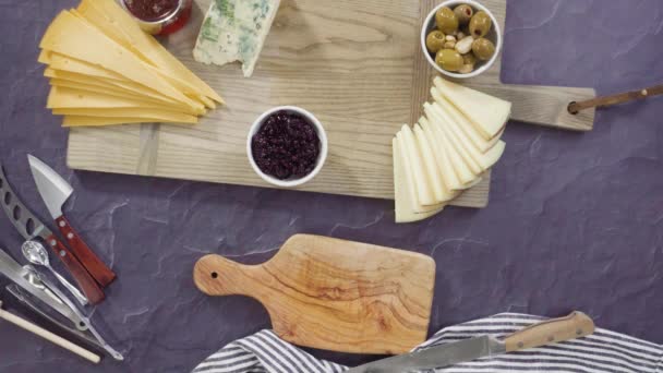 平置きだ 大規模なチーズボードのためのボード上のグルメチーズ クラッカー 果物の手配 — ストック動画