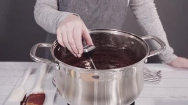 Basit çikolatalı şekerlemeler yapmak için yemek kabındaki malzemeleri karıştırıyorum..