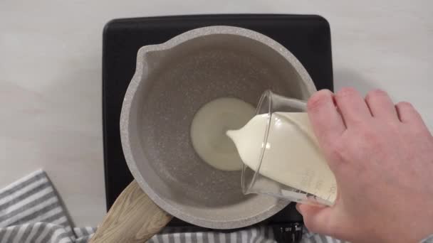 一步一步 平躺在床上在电锅上的小平底锅里准备巧克力糖霜 — 图库视频影像