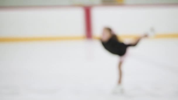 小さな女の子練習フィギュアスケート上の屋内アイススケートリンク — ストック動画