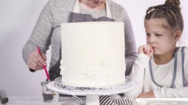 Adım adım. Yuvarlak funfetti pastasını pembe ve beyaz fondant kar taneleriyle süslüyorum..