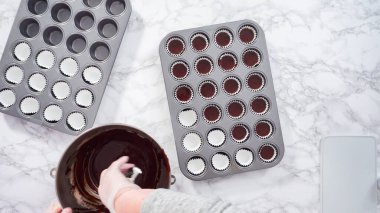 Düz yatıyordu. Adım adım. Mini çikolatalı kekler pişirmek için kek hamurunu mini kek kuyruklarına karıştırmak..