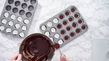 Düz yatıyordu. Adım adım. Mini çikolatalı kekler pişirmek için kek hamurunu mini kek kuyruklarına karıştırmak..