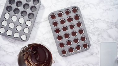 Düz yatıyordu. Adım adım. Mini çikolatalı kekler pişirmek için kek hamurunu mini kek kuyruklarına karıştırmak..