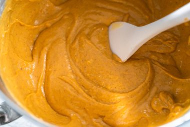 Plastik spatulayla karıştırılmış kabaklı baharatlı kek hamuru..