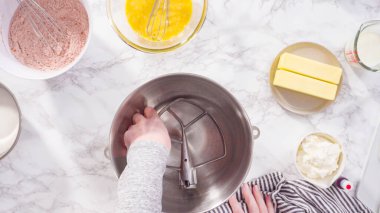 Düz yatıyordu. Adım adım. Kırmızı kadife kekler pişirmek için mutfak mikserinin malzemelerini karıştırıyorum..