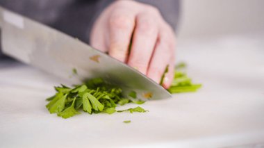 Vejetaryen fasulye çorbası pişirmek için sebzeleri doğramak..