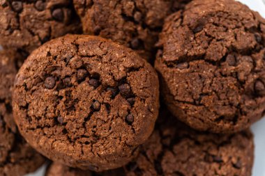 Taze pişmiş çifte çikolatalı kurabiyeler beyaz tabakta..