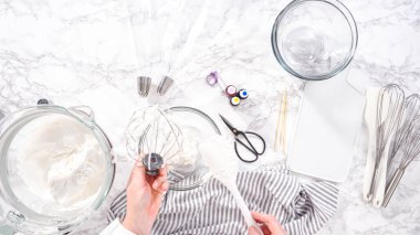 Adım adım. Düz yatıyordu. Tek boynuzlu at kurabiyesi pişirmek için besin boyasını kremaya karıştırıyorum..