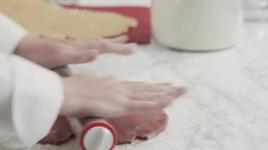 Adım adım. Kırmızı, beyaz ve mavi fırıldak şekerli kurabiyeler pişirmek için hamuru yuvarlıyor..