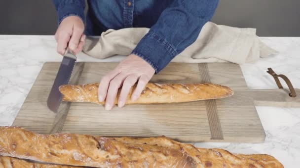 Розрізання Свіжоспеченого Пшеничного Хліба Білій Обробній Дошці — стокове відео