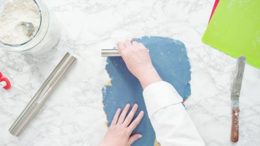 Adım adım. Düz yatıyordu. Kırmızı, beyaz ve mavi fırıldak şekerli kurabiyeler pişirmek için hamuru yuvarlıyor..