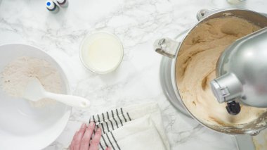 Adım adım. Düz yatıyordu. Üç katlı vanilyalı kek pişirmek için mutfak mikserinin malzemelerini karıştırıyorum..