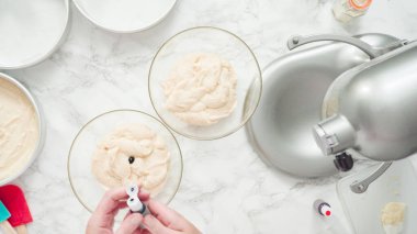 Adım adım. Düz yatıyordu. Üç katlı vanilyalı kek pişirmek için yemek boyasını kek hamuruna karıştırıyorum..