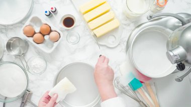 Adım adım. Düz yatıyordu. Üç katlı vanilyalı kek pişirmek için tereyağlı kek tavaları yağlamak..